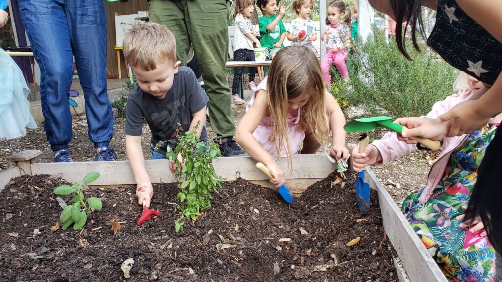 Montessori students developing gardening skills outside