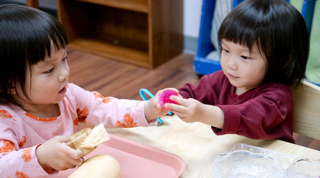 two children play together at montessori school