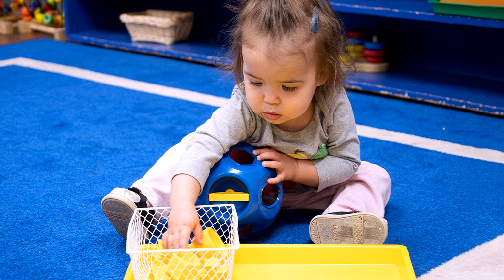 A child learns her shapes in a montessori preschool