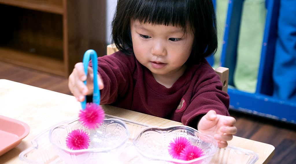 a child learns practical life skills in a montessori preschool