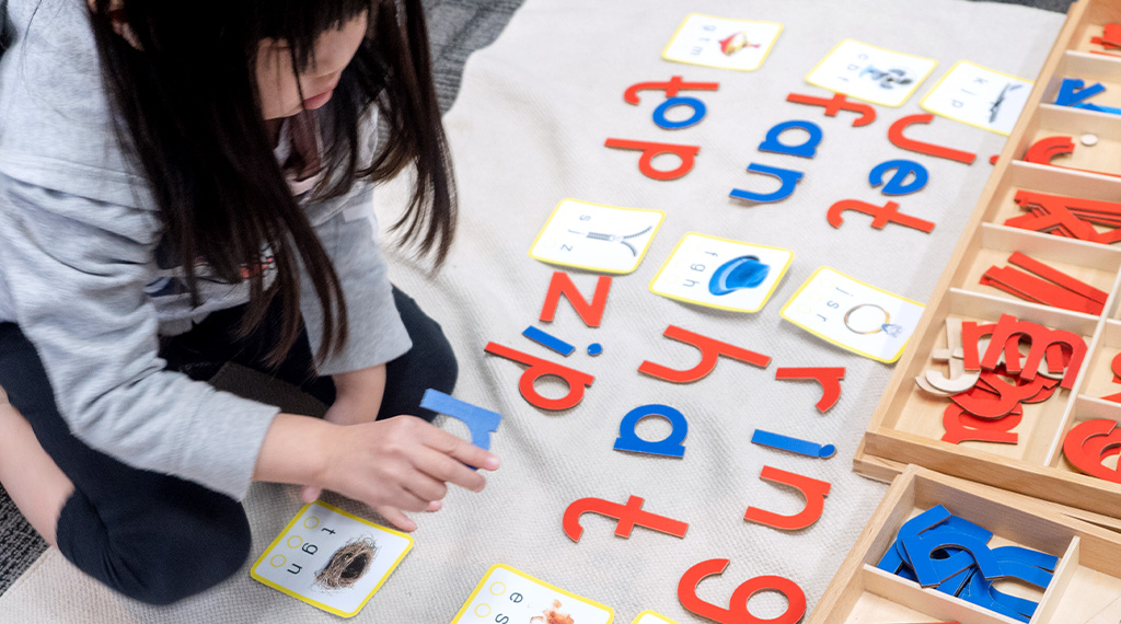 a child learns how to spell using games in a montessori school