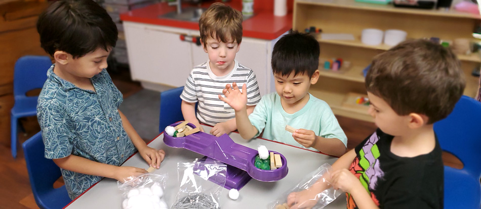 Two young boys learn about balance and measuring by playing a game at a Montessori school in Austin