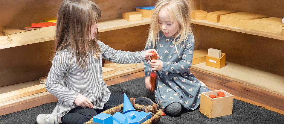 Two girls play with blocks in a Montessori classroom in Austin