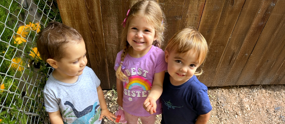 Three kids play outside at a Montessori school in Austin