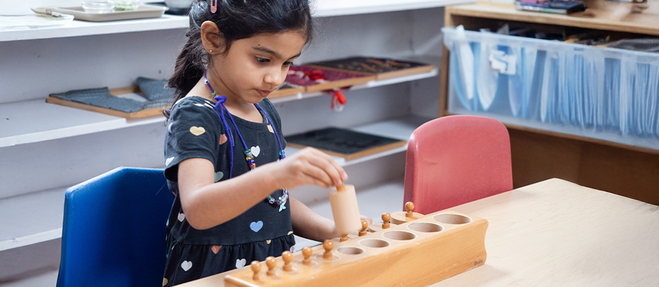 A Montessori student learns about shapes and sizes