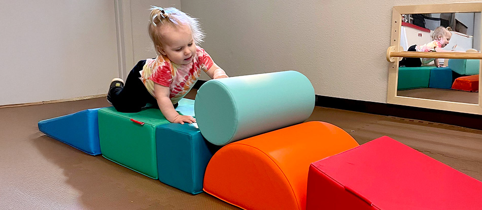 young toddler plays with foam blocks in Montessori preschool