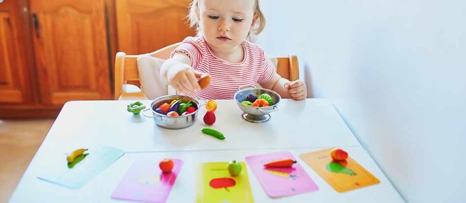 montessori child learns the alphabet by playing with fruit toys